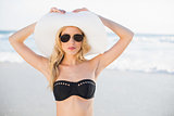 Gorgeous blonde in bikini wearing straw hat and sunglasses