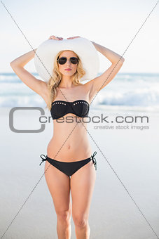 Attractive blonde in bikini wearing straw hat and sunglasses