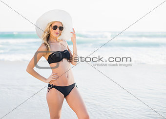 Attractive blonde in elegant black bikini looking at camera