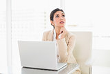 Thinking businesswoman working with a laptop