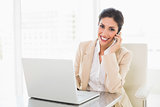 Happy businesswoman working with a laptop on the phone