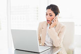 Surprised businesswoman working with a laptop on the phone
