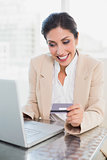 Cheerful businesswoman shopping online with laptop