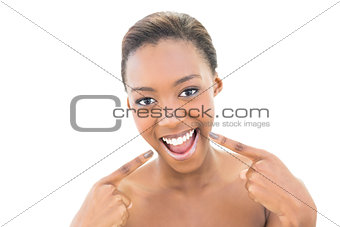 Smiling natural beauty pointing at her smile