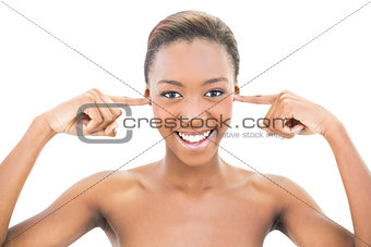 Smiling nude beauty covering her ears