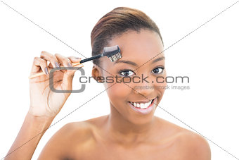 Smiling natural beauty using eyebrow brush