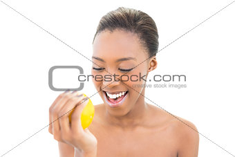 Cheerful natural model holding orange