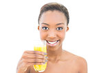 Smiling natural beauty holding glass of orange juice