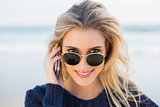 Cheerful gorgeous blonde on the phone looking over her sunglasses