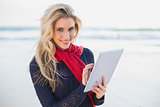 Smiling sexy blonde holding tablet computer