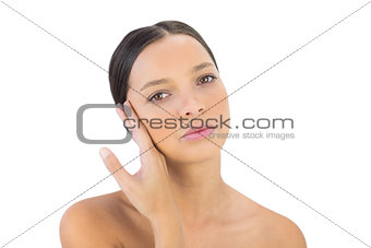 Unsmiling woman holding hand on face