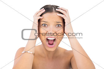 Screaming woman holding hands on head