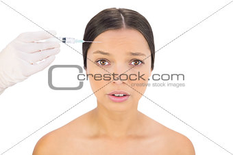 Anxious bare model having botox injection on forehead