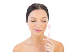 Brunette woman looking at her teeth brush