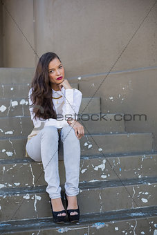 Attractive woman with red lips sitting on stairs