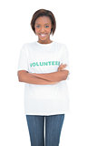 Smiling volunteer woman standing crossing arms