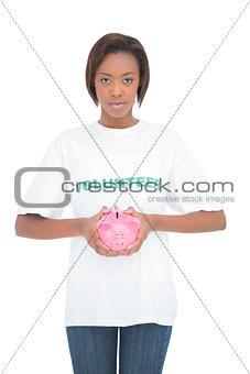 Serious woman holding piggy bank