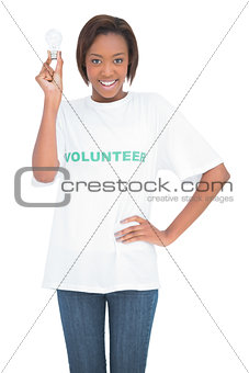 Smiling volunteer woman holding light bulb