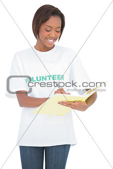 Cheerful volunteer woman writing on notebook