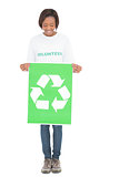 Happy volunteer woman holding recycling sign