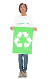 Volunteer woman holding recycling sign looking up