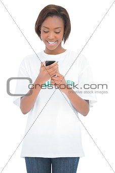 Cheerful volunteer woman looking at her mobile phone