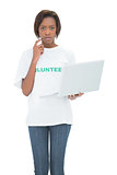 Serious volunteer woman using laptop