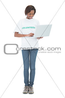 Cheerful volunteer woman using laptop