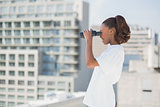 Side view of pretty woman using binoculars