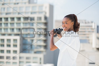 Woman with binoculars looking at camera
