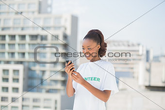 Smiling volunteer holding her mobile phone