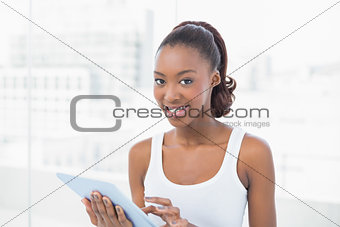 Cheerful sporty model holding tablet pc