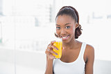 Happy sporty model holding glass of orange juice