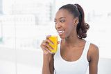 Cheerful sporty model holding glass of orange juice
