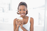 Cheerful sporty model holding coffee