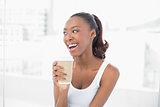Laughing sporty woman holding coffee