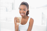 Smiling sporty woman holding coffee