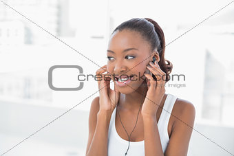 Cheerful athletic woman listening to music