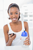 Peaceful athletic woman holding smartphone