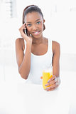 Happy athletic woman phoning holding orange juice