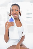 Smiling athletic woman holding flask