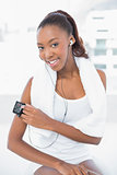 Cheerful athletic woman changing music on her mp3