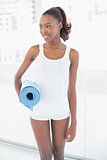 Attractive woman holding exercise mat