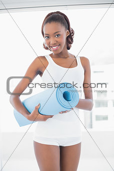 Beautiful woman posing with exercise mat