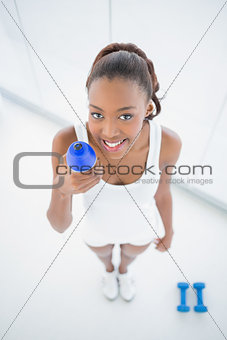 High angle view of smiling fit woman holding flask