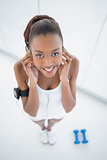 High angle view of smiling fit woman listening to music