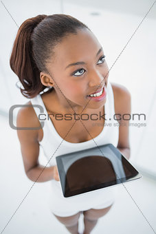 High angle view of cheerful sporty woman holding tablet