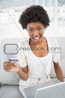 Happy gorgeous woman using her credit card to buy online