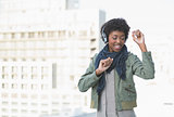 Smiling casual model dancing while listening to music