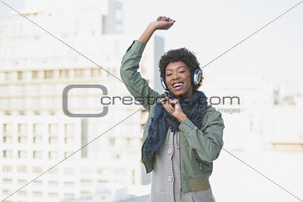 Cheerful casual model dancing while listening to music